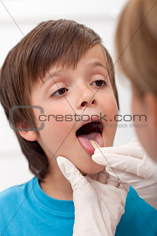 Boy showing her throat to health professional