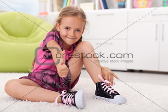 Little girl learning how to tie her shoes