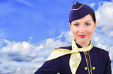 Beautiful young  smiling stewardess on a background sky