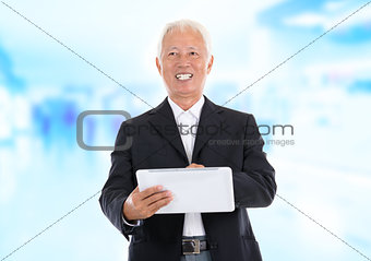Asian senior businessman using tablet-pc