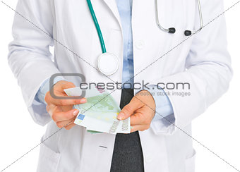 Closeup on medical doctor counting euros