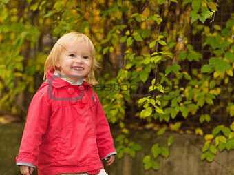 Portrait of happy baby in red coat outdoors