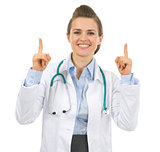Smiling medical doctor woman pointing up