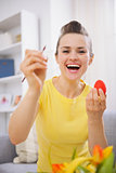 Happy young woman painting Easter eggs