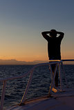 Person enjoying an ocean sunset