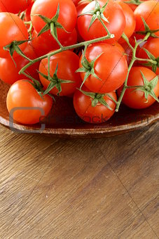 Fresh cherry tomatoes on wooden plate