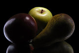 apple and pear on black background
