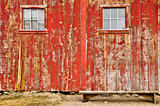Red old barn with windows and lonely bench