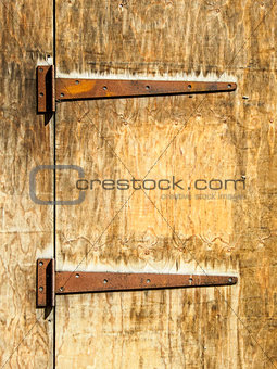 Rusty hinges on an old wooden door