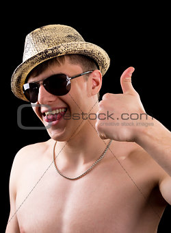 Joyful young man in hat showing thumb up