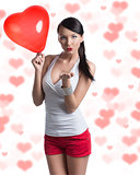 sexy brunette with heart shaped balloon sends a kiss