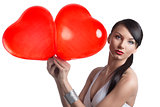 sexy brunette takes two heart shaped balloons with both hands