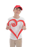 Daydreaming boy holding red love heart