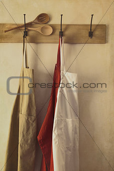 Kitchen aprons hanging on hooks with vintage feel
