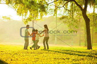 Happy asian family playing on the field