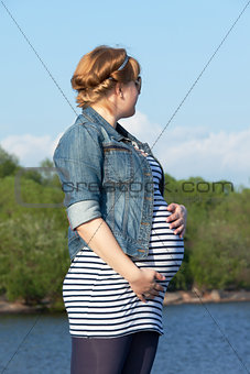 Pregnant woman on the river coast