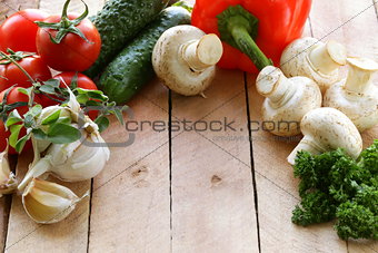 frame of vegetables (cucumber, tomato,mushrooms, garlic)  on a wooden background