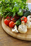 tomatoes, cucumbers, mushrooms and parsley on a cutting board