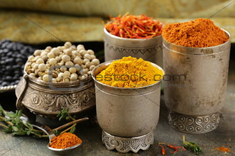 various spices (turmeric, paprika, saffron, coriander) in metal bowls