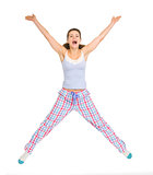 Smiling young woman in pajamas jumping