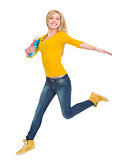 Smiling student girl with books jumping
