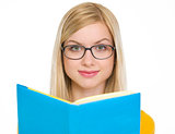 Happy student girl reading book in glasses