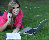 Young student outside in the park with  computer and notebook st
