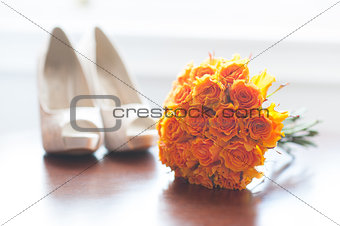 wedding shoes and bouquet of orange roses