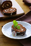 chocolate cake  roll with vanilla cream on a wooden board