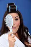 Funny woman with hair rollers and brush