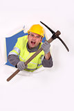 Construction worker breaking through a barrier with a pickaxe
