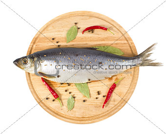 herring with spice on wooden plate