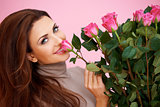 Beautiful woman smelling a rose