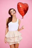 Vivacious brunette with a red heart balloon