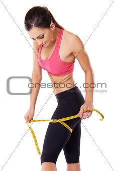 Strong female athlete measuring her thigh