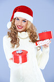 Pretty woman in Santa hat holding Christmas gifts