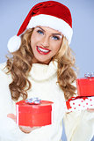Close up of woman in Santa hat holding Christmas gifts