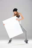 Young fashionable modern dancer holding empty board