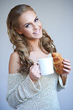 Cute girl holding white cup of hot drink while isolated