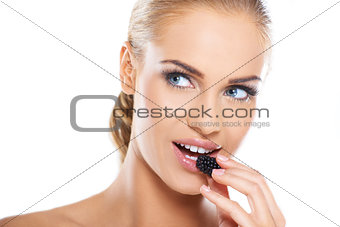 Close up of beautiful woman eating blackberries