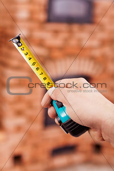 Construction worker hand with tape-measure