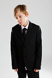Serious young boy wearing black suit