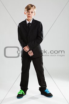 Young boy in black suit and colorful shoes