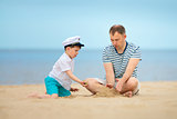 Young loving father and her little son playing on the beach