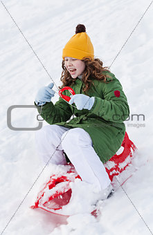 Girl rides sledge down hill