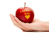 ripe red apple with the words "I love you" holding in hand