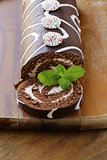 chocolate cake  roll with vanilla cream on a wooden board