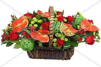 Red-and-green floral arrangement in a wicker basket.