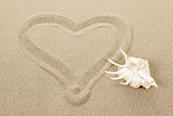 handwritten heart on sand with seashell