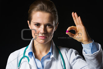 Medical doctor woman showing tablets isolated on black